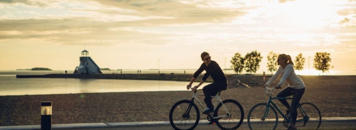 Decorative element: BSTF Banner with two people biking at the sea side on a sunny day