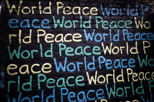 Decorative element: World Peace written in different colours on a black wall